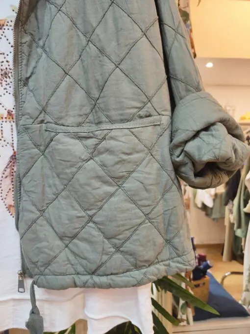 Chaqueta guateada de entretiempo. Corte cuadrado, bolsillos en la parte delantera y cordon ajustable.