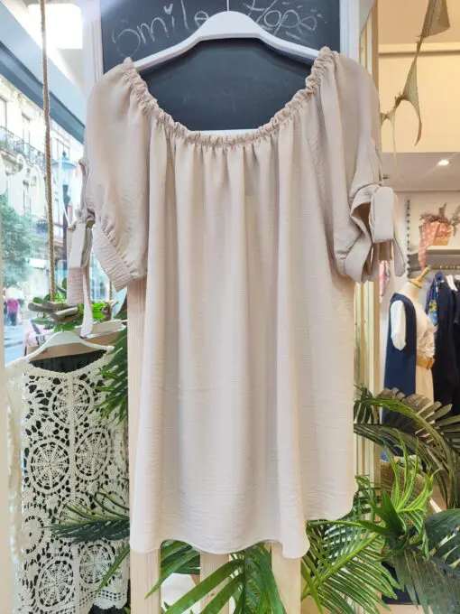 Blusa fluida lazo. Blusa fluida con escote elástico tipo barco, ideal para llevar con los hombros al aire. Detalle de lazo en las mangas cortas que le aporta un toque femenino y elegante. Su tejido suave y ligero la convierte en una prenda perfecta para el verano.