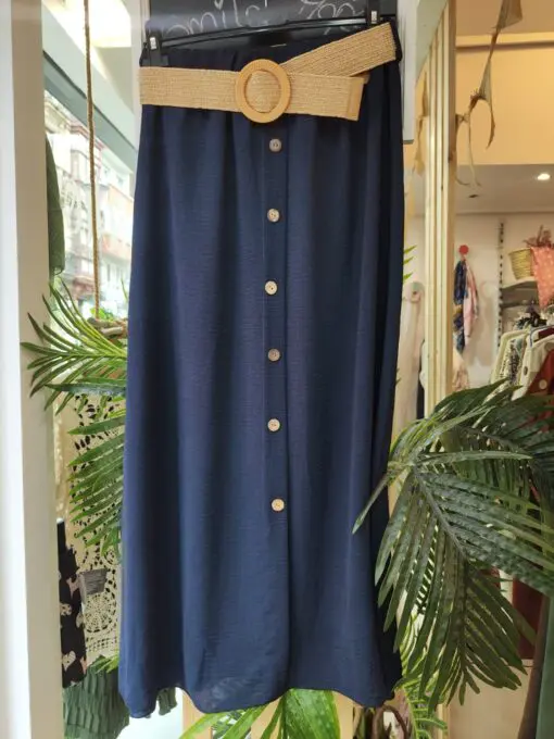 Falda botones azul marino. Falda larga de estilo fresco y elegante, con botonadura frontal decorativa y cinturón de rafia con hebilla redonda que realza la cintura. Confeccionada en tejido fluido, ideal para el verano. Talla única, cómoda y versátil. Disponible en varios colores.