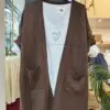 Cardigan CACAO1. Cárdigan largo de punto suave en tono marrón chocolate. Diseño abierto, con bolsillos delanteros amplios y detalle de canalé en bajos y puños. Perfecto para entretiempo o para añadir un toque cálido a tus looks diarios.