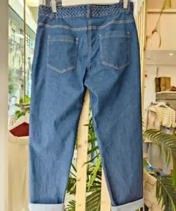 . Pantalón vaquero azul medio con bajo vuelto y cinturón trenzado a juego. Corte recto y cómodo, ideal para looks diarios con un toque especial.