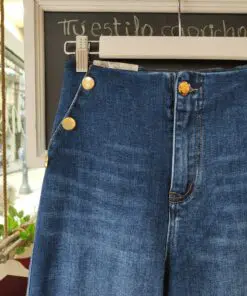 Denimbotones1. Descripción: Vaquero de tiro alto con detalle de botones dorados estilo marinero. Corte recto, cómodo y favorecedor. Perfecto para elevar cualquier look casual con un toque original y sofisticado.