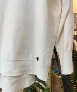 jerseypunto2. Jersey blanco de punto fino, con cuello redondo y costura central decorativa. Suave, ligero y perfecto para entretiempo. El detalle del corazón bordado en el bajo lo hace aún más especial.