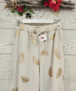 Pantalón cintura elástica con cordón ajustable, bolsillos laterales y corte recto. Fondo beige con lurex.