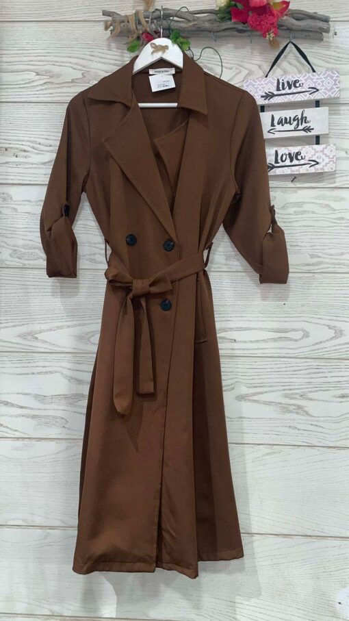 Gabardina TRENCH de cuello solapa, manga larga ajustable el largo con trabilla acabada en botón.Bolsillos laterales. Cierre con doble botonadura y cinturón del mismo tejido.