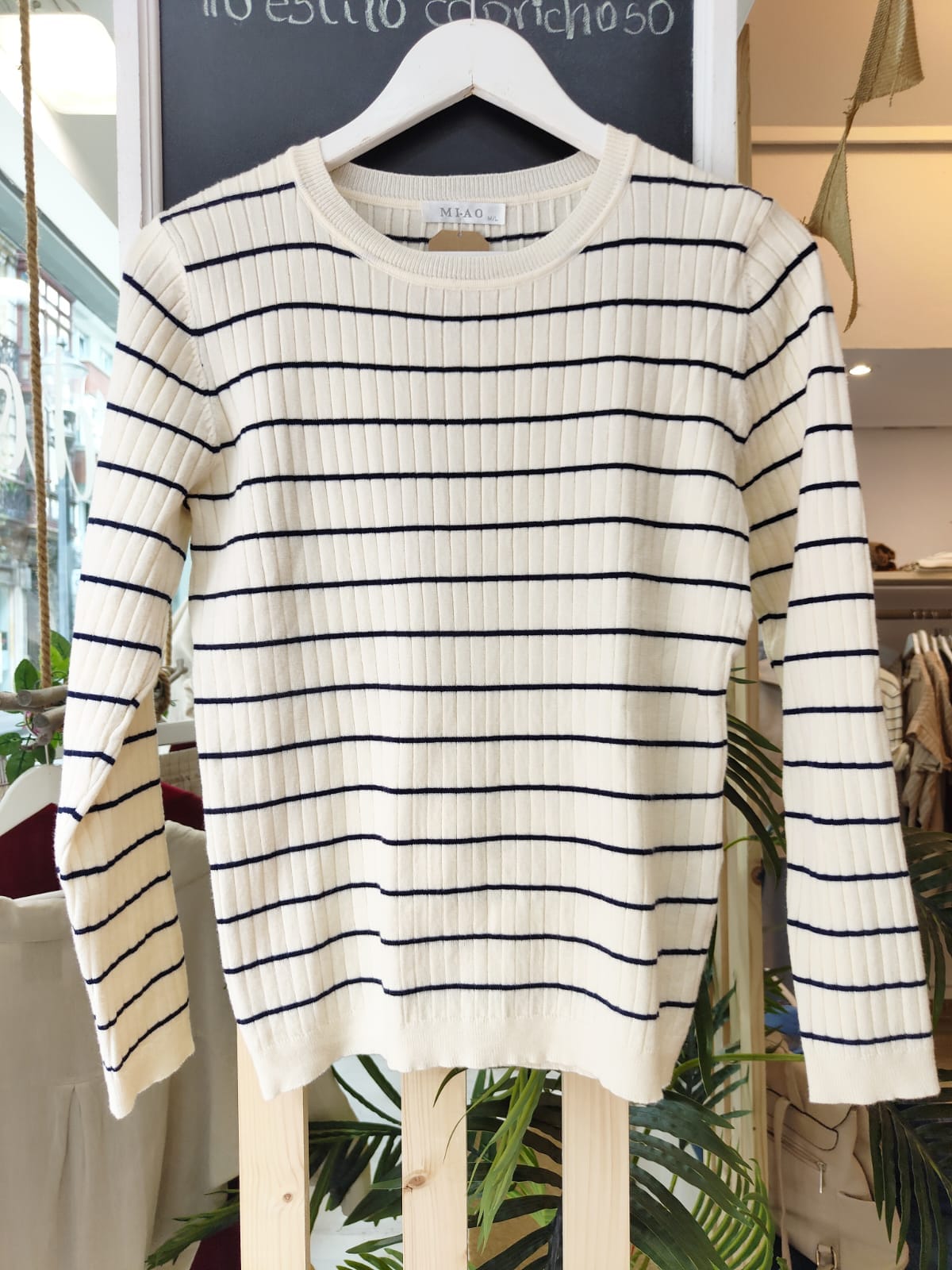 Jersey CANALE Jersey CANALE. Jersey de punto canalé en color crudo con finas rayas horizontales en azul marino. Corte recto y cuello redondo, ideal para un look clásico con aire marinero. Su tejido elástico y suave lo convierte en una prenda cómoda y versátil para el día a día.