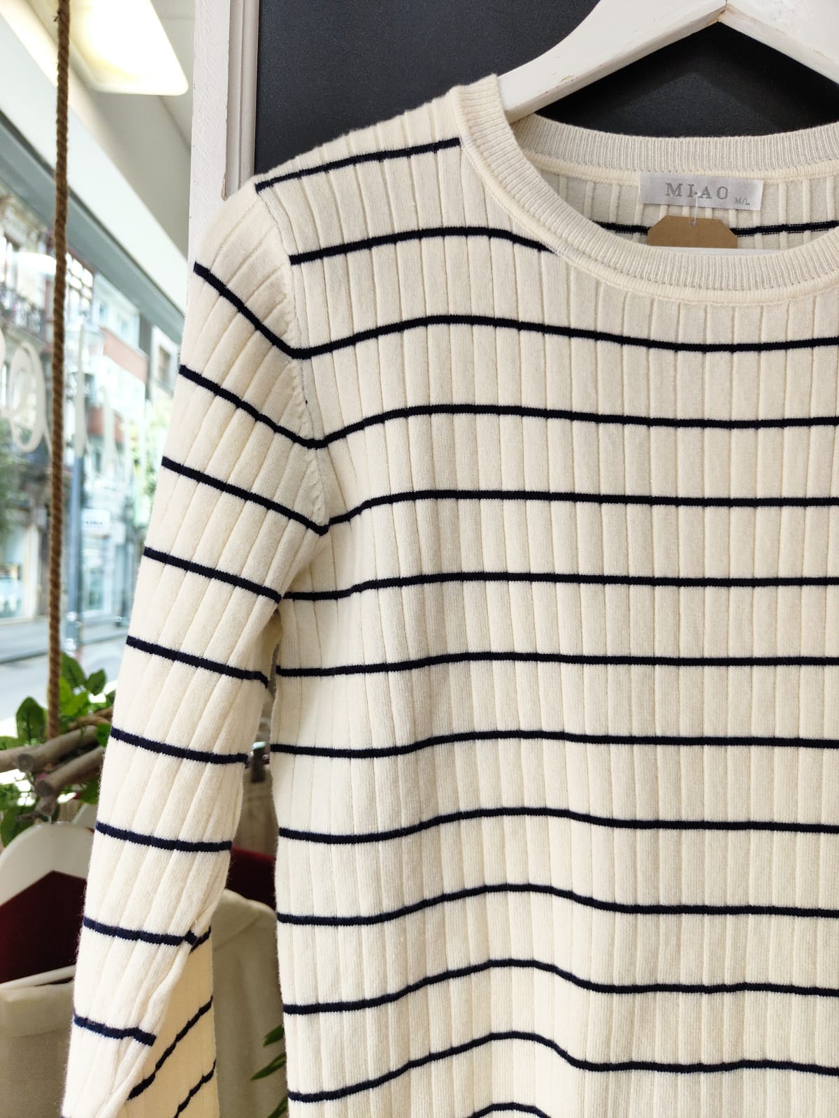 Jersey CANALE1 Jersey CANALE1. Jersey de punto canalé en color crudo con finas rayas horizontales en azul marino. Corte recto y cuello redondo, ideal para un look clásico con aire marinero. Su tejido elástico y suave lo convierte en una prenda cómoda y versátil para el día a día.